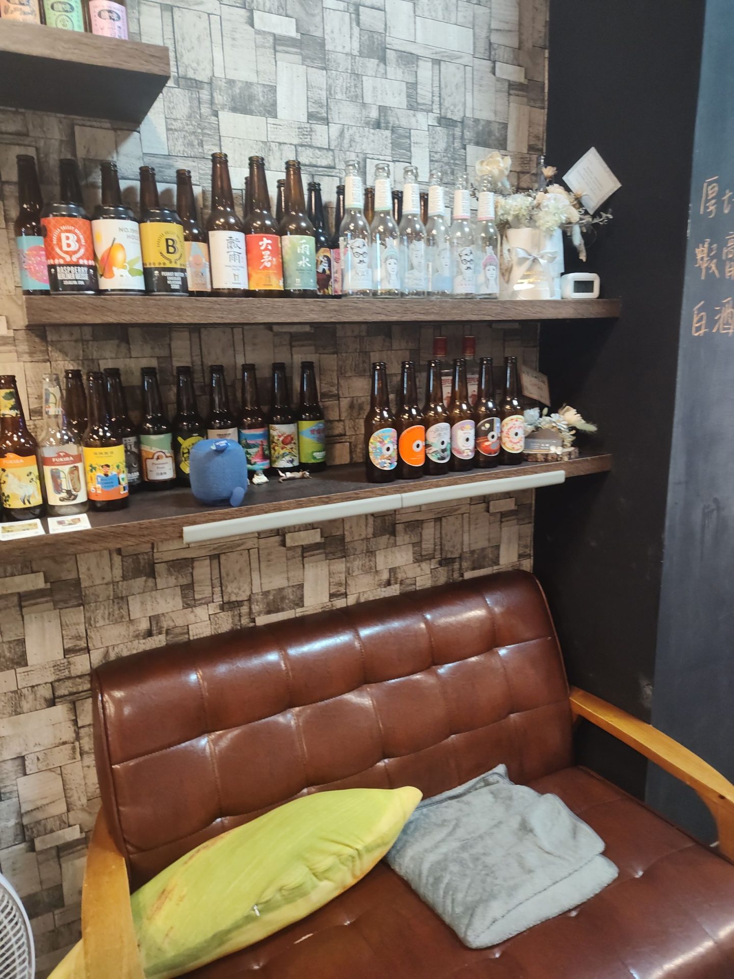 基隆私嶼 private island 棕色皮革沙發座位區與精釀啤酒展示牆