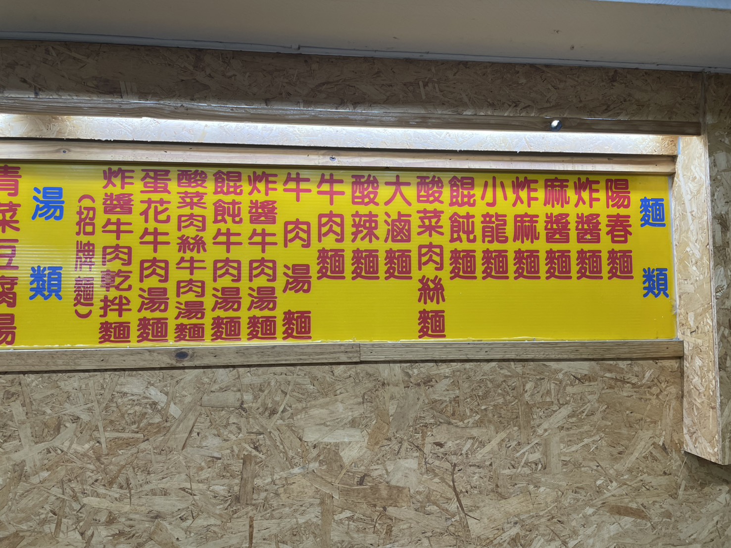 小龍飲食牆上黃色大字菜單,麵類品項一覽